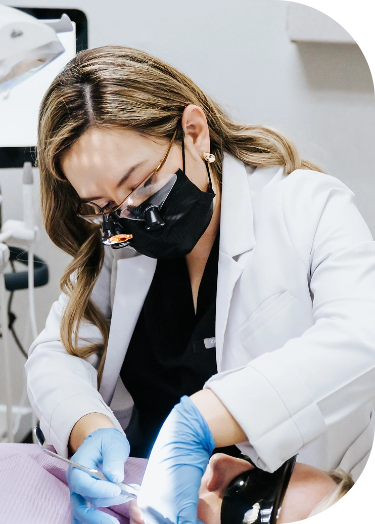 Masked EZ Dental dentist focused on patient treatment in Fort Myers, FL