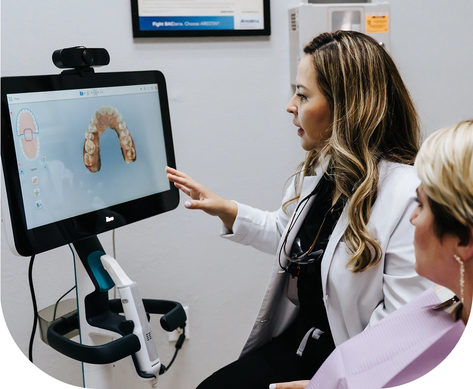 EZ Dental dentist reviewing a patientu2019s smile results on a chairside monitor in Fort Myers, FL