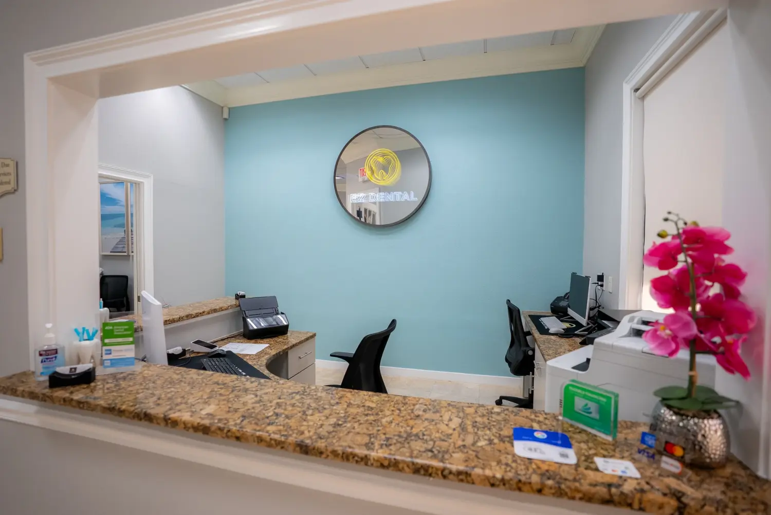 Welcoming EZ Dental front desk with orchid accents in Fort Myers, FL