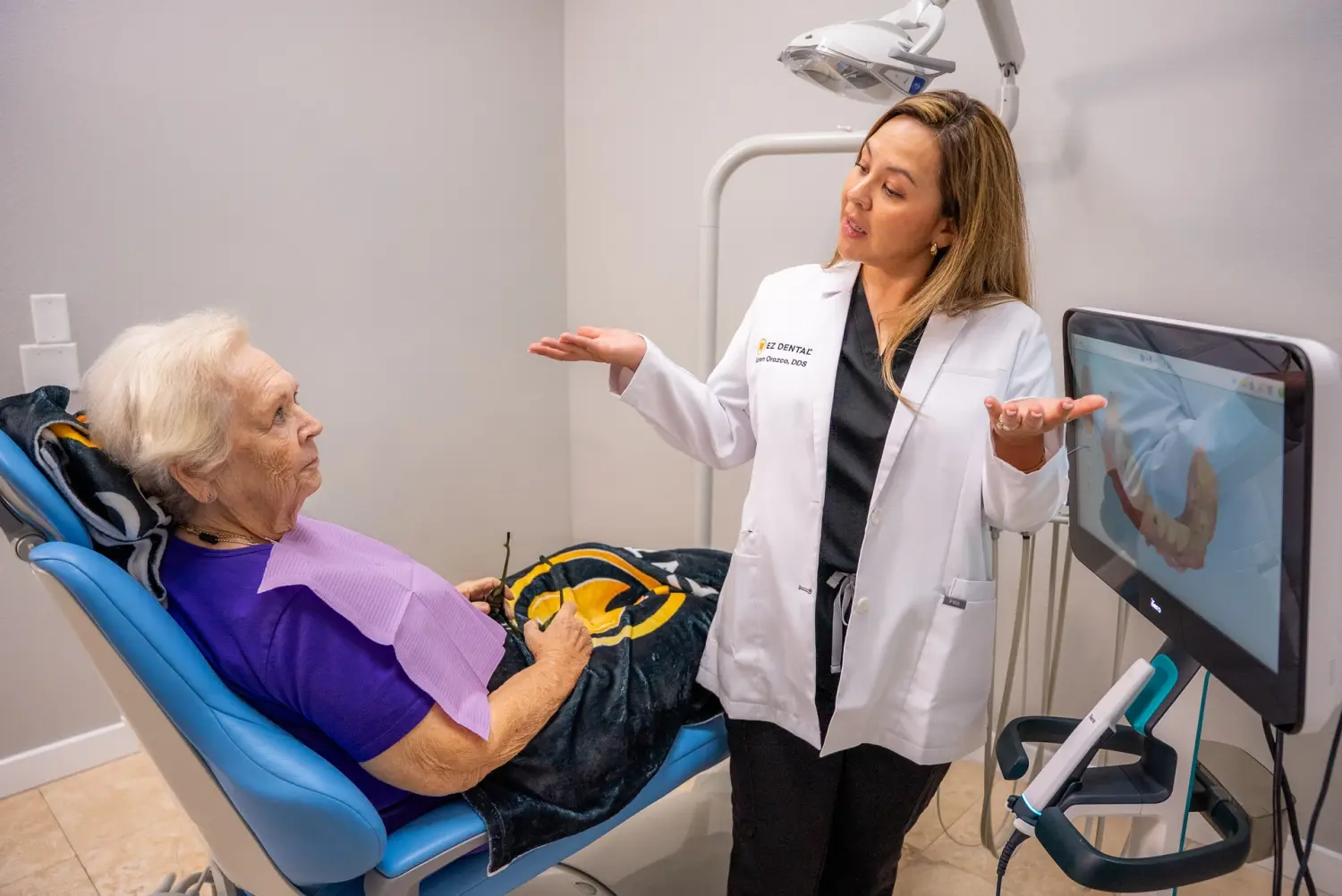 EZ Dental dentist explaining treatment to senior patient in chair in Fort Myers, FL