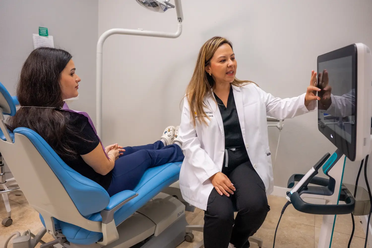 Dr. Karen Orozco consulting with a smiling patient at EZ Dental office in Fort Myers, FL